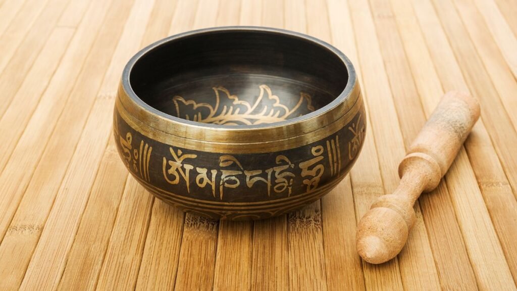 Tibetan singing bowl producing a deep OM vibration during a sound healing meditation session
