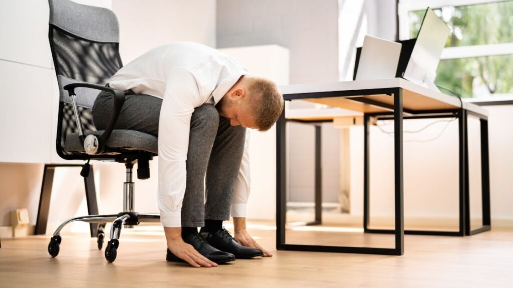 Sthira Sukham Asanam: What It Really Means and Why It Still Matters 2 a person doing desk yoga at the office