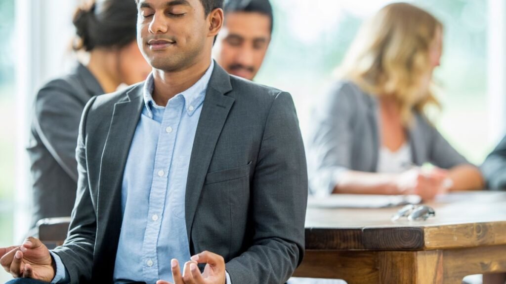 Sthira Sukham Asanam: What It Really Means and Why It Still Matters 1 a person meditating in the office