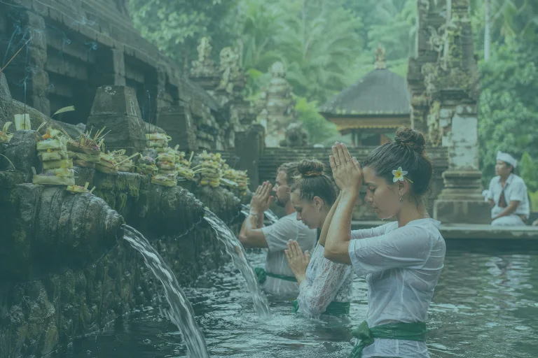 Yoga teacher training students taking part in a Balinese water purification ceremony at a sacred temple in Bali.
